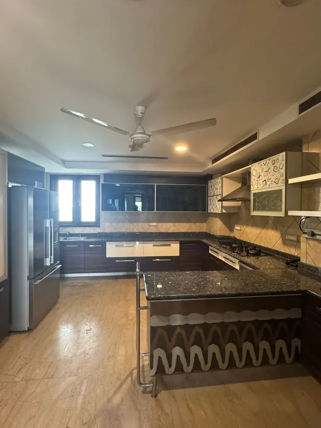 Modern modular kitchen with servant quarter access at Ambience Caitriona Island- The Soni Lanbase