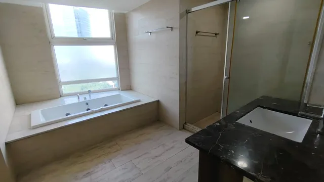 Ultra-luxury master bathroom with bathtub and premium marble flooring at DLF The Belaire Sector 54.- The Soni Landbase