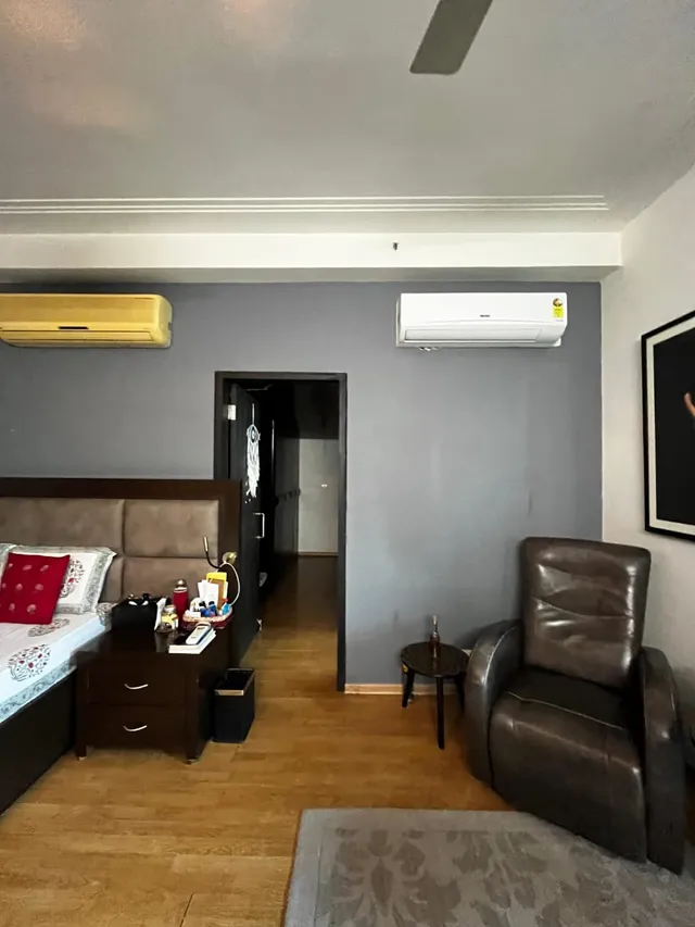 Elegant master bedroom suite with premium wall paneling at DLF The Pinnacle Sector 43.- The Soni Landbase